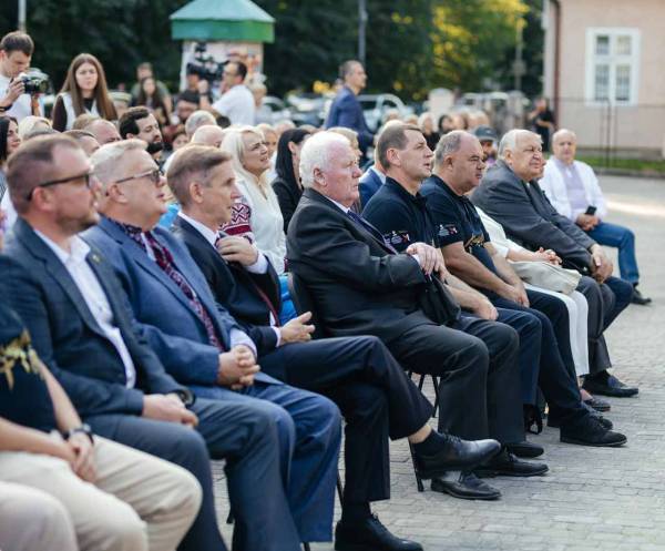 Гості, науковці та меценати сидять у рядах на відкритому повітрі під час урочистостей у Дрогобичі.
