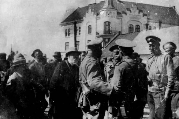 Президент міста Львова Т. Рутовський передає символічні ключі від міста російському генералу В. Роде. На задньому плані – будівля Львівської ЗОШ № 63 на вул. Личаківській, 179. Світлину зроблено 3 вересня 1914 р.