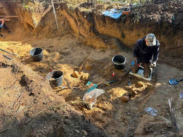 Пошуковець розчищає останки вояка під час розкопок на Голосківському цвинтарі біля Львова