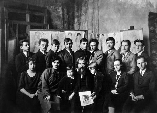 У майстерні Мистецької школи Олекси Новаківського. Сидять зліва направо: С. Гебус, М. Карп'юк, О. Новаківський із синами, О. Плешкан, Г. Смольський. Стоять (зліва направо): С. Луцик, А. Малюца, В. Булик, П. Годис, С. Гординський, М. Мороз, В. Гриценко, Л. Пацуркевич, Л. Папара. Фото 1927 р.